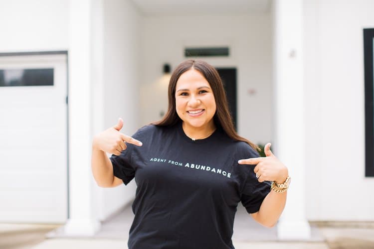 A lady pointing her fingers to her shirt